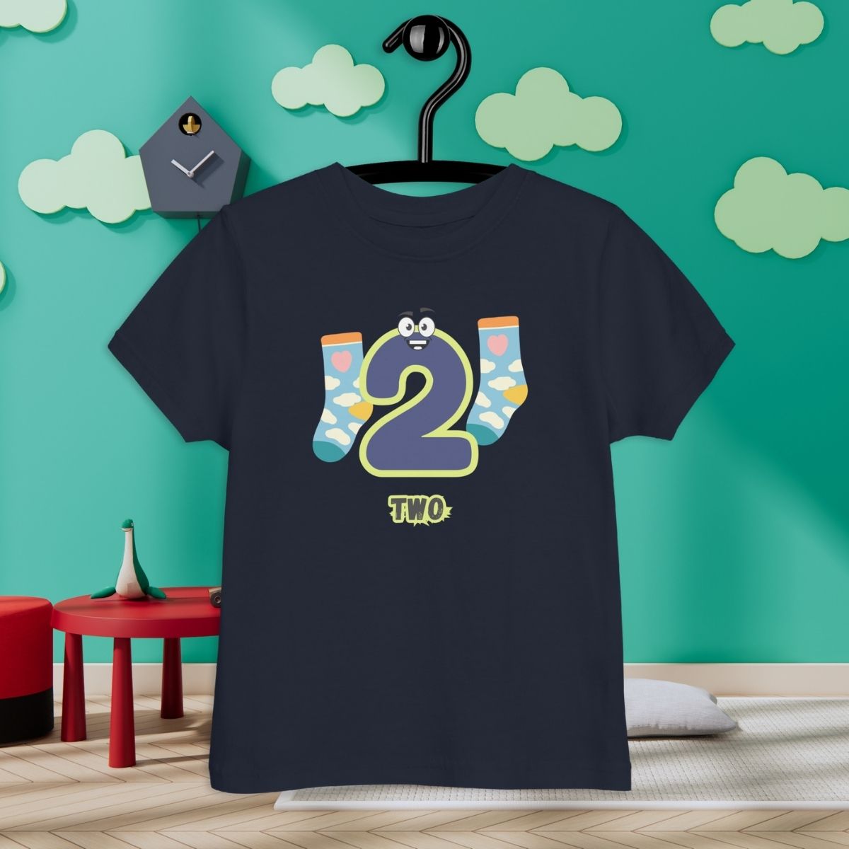 Navy Blue Kid's Shirt designed with number 2 and with a pair of socks in room with clouds background